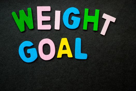 Colorful wooden letters forming the phrase "weight goal"