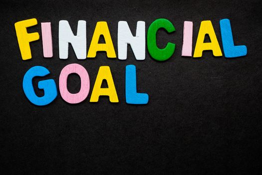 Colorful wooden letters forming the phrase "financial goal"