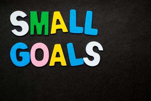 Colorful wooden letters forming the phrase "small goals"
