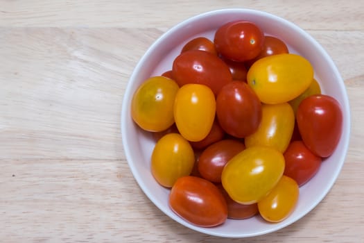 Red and yellow cherry tomatoes in a bowl.