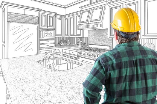 Male Contractor with Hard Hat and Tool Belt Looking At Custom Kitchen Drawing Photo Combination On White.