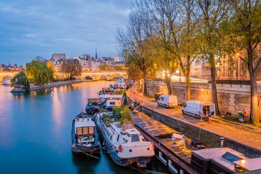 The Seine river with boats at night with lights on