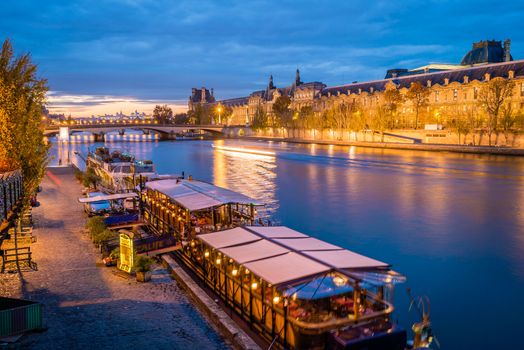 Peniche boats on the Seine river in Paris at night