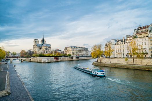 Notre-dame-de-Paris, the Seine river and a boat in Paris in autumn