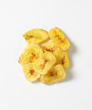 Heap of dried thin banana slices on white background