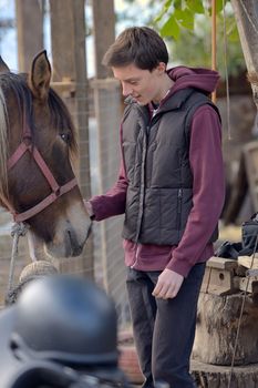 Happy teenager boy with horse at ranch