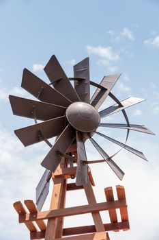 Metal windmill against a blue sky on a farm in summer