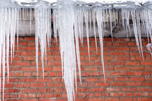 Icecles on background with red brick wall