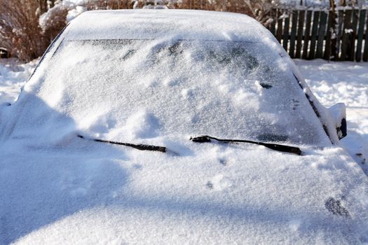 Winter country landscape. Closeup frozen car under snow 