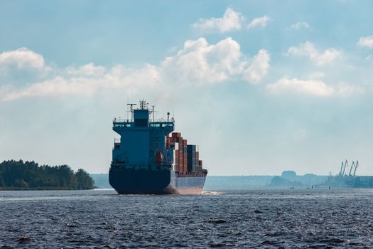 Blue container ship in travel. Logistics and freight industry