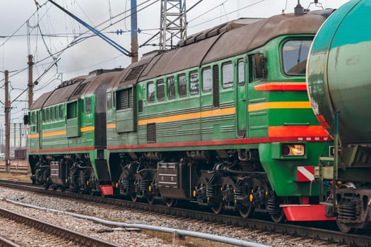 Green diesel cargo locomotive. Freight train in action