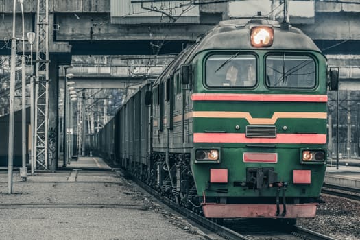 Green diesel cargo locomotive. Freight train in action