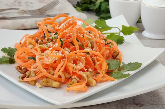 Carrot ribbon salad bathed with yoghurt dressing seasoned with fried nuts and sesame seeds, fresh coriander