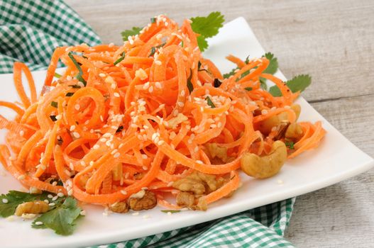 Carrot ribbon salad bathed with yoghurt dressing seasoned with fried nuts and sesame seeds, fresh coriander