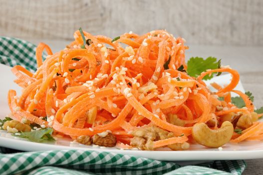 Carrot ribbon salad bathed with yoghurt dressing seasoned with fried nuts and sesame seeds, fresh coriander