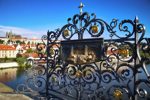 Panoramic view on St. Vitus Cathedral from Charles Bridge with Wenceslaus and Sigismund and bronze relief for good luck in Prague, Czech Republic