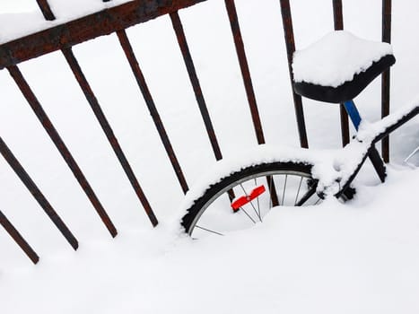 Bicycle in a snowdrift, after snowstorm. Canadian winter.