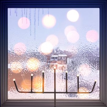 Winter composition with frosted window and lights. Christmas mood.