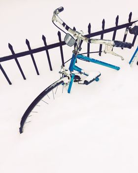 Bicycle stuck in deep snow, after a snowstorm.