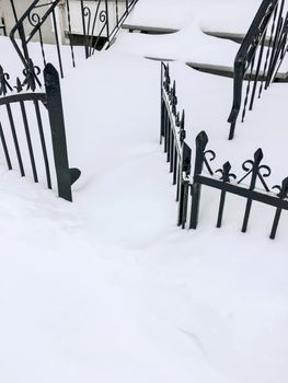 Iron fence in deep snow. Canadian winter.