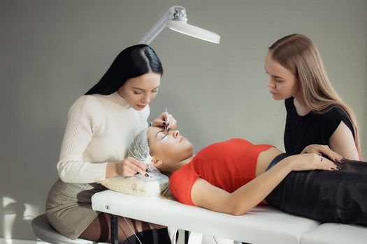 young woman working on eyelash extensions. Woman Eye with Long Eyelashes.