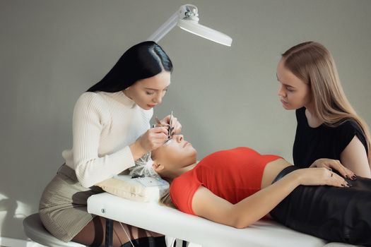 young woman working on eyelash extensions. Woman Eye with Long Eyelashes.