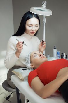 young woman working on eyelash extensions. Woman Eye with Long Eyelashes.