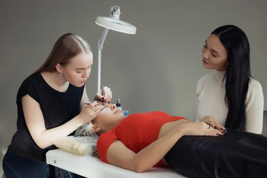 young woman working on eyelash extensions. Woman Eye with Long Eyelashes.