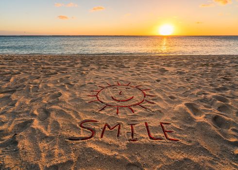 Handwritten on the sand "Smile".Beautiful sand beach at sunset.