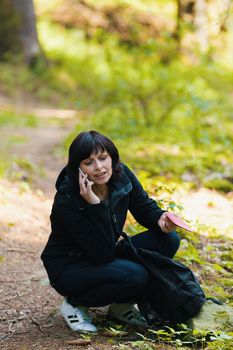 Middle age woman, on hiking trip, lost in forest, calling from mobile cell phone for help.
