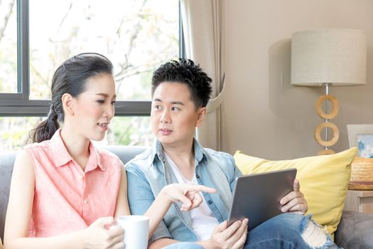 Young Couples using tablet tohether in living room of contemporary house for modern lifestyle concept