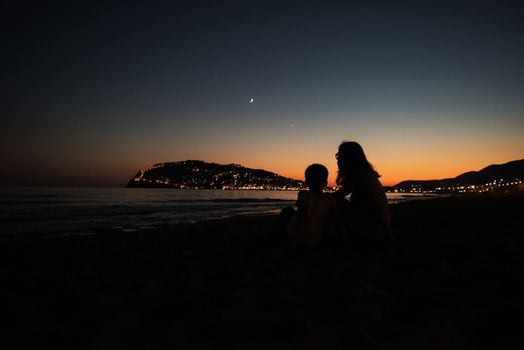 mother and son on the pier in the evening at Alania, Turkey