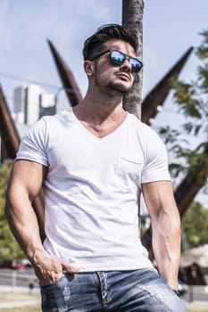 Attractive man in urban setting in front of big metal structure