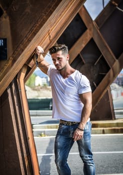 Attractive man in urban setting in front of big metal structure