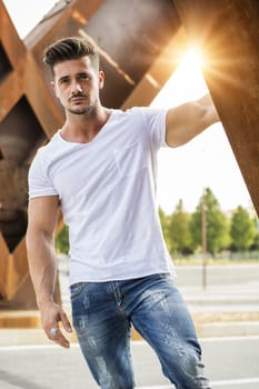 Attractive man in urban setting in front of big metal structure