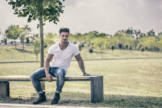 Attractive muscular man in city park in a nice summer day