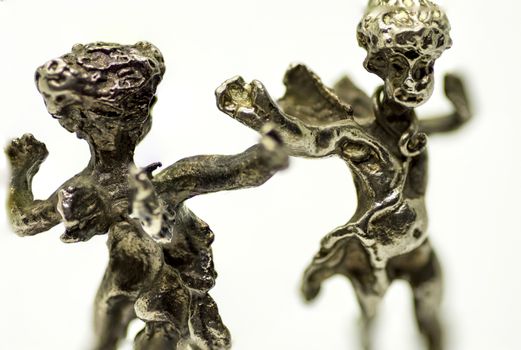 two metallic figurine angels are dancing