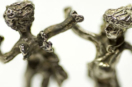 two metallic figurine angels are dancing