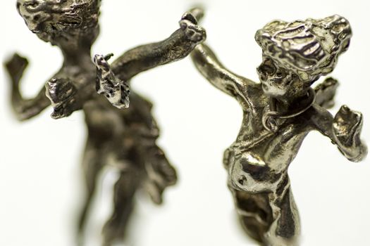 two metallic figurine angels are dancing