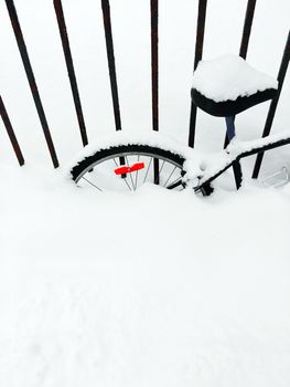 Bicycle deep in snow, after snowstorm. Canadian winter.