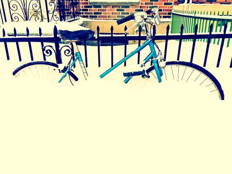 Bicycle in snow, after snowstorm, near an urban building. Retro style photo.