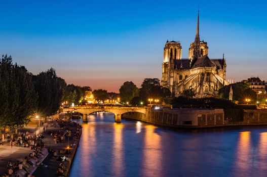 Notre Dame de Paris and Seine wharf at night in the summer