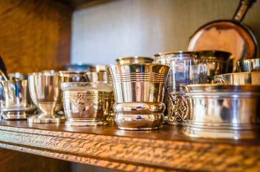 French metal eggcups on a shelf with bronze and silver eggcups