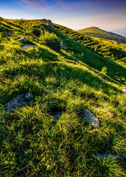 mountain ridge with peak behind the hillside. beautiful summer background at sunset with reddish sky