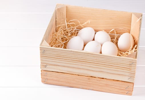 EA dozen white eggs in a wooden box