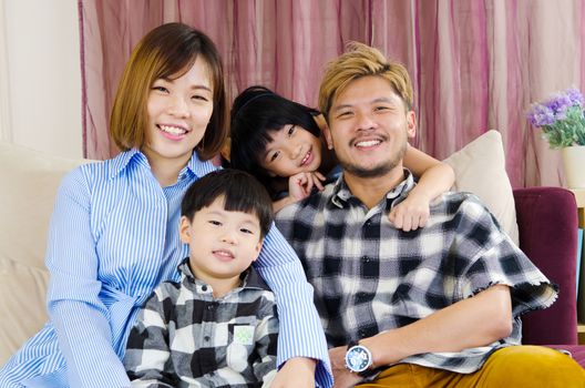 Portrait of asian family siting on the sofa at home.