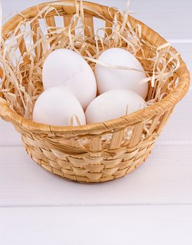 Eggs in basket on the white background