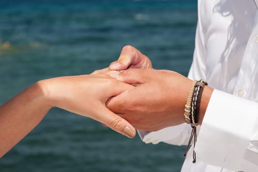 hands of wedding couple changing rings