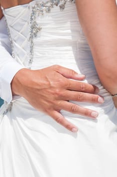 close up of groom's hand holding the bride