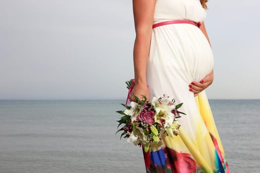 close up of a pregnant girl holding a bouquet of flowers